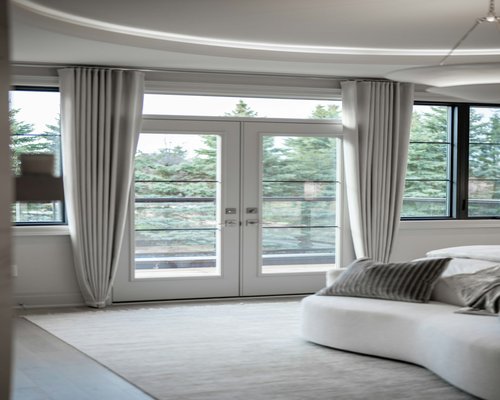 A modern living room window filtered with soft thin white curtains letting smooth day light enter