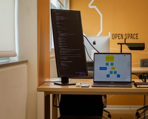Close up of a computer display showing code with pleasant contrast in a well lit coworking desk